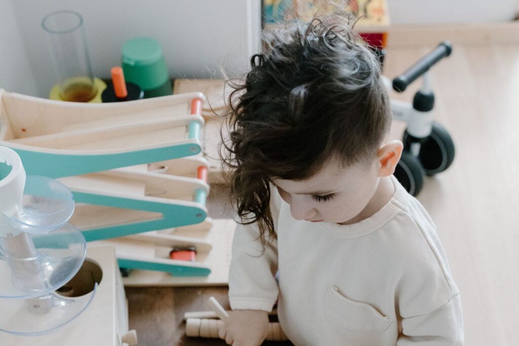 A young child playing with wooden toys