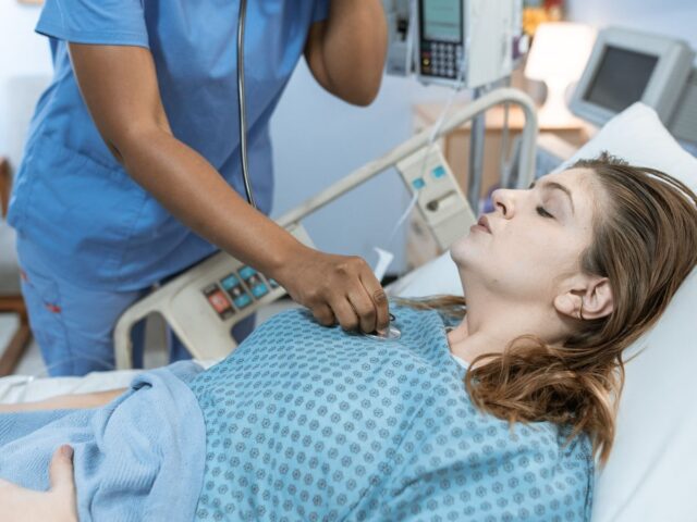 Nurse checking a patient with a stethoscope