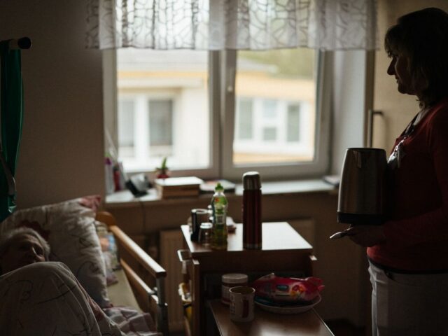 Caregiver preparing a warm drink for a senior at home